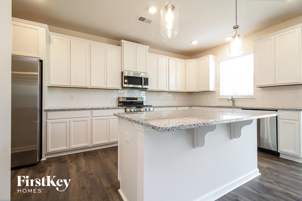 A kitchen with white cabinets and a granite countertop.