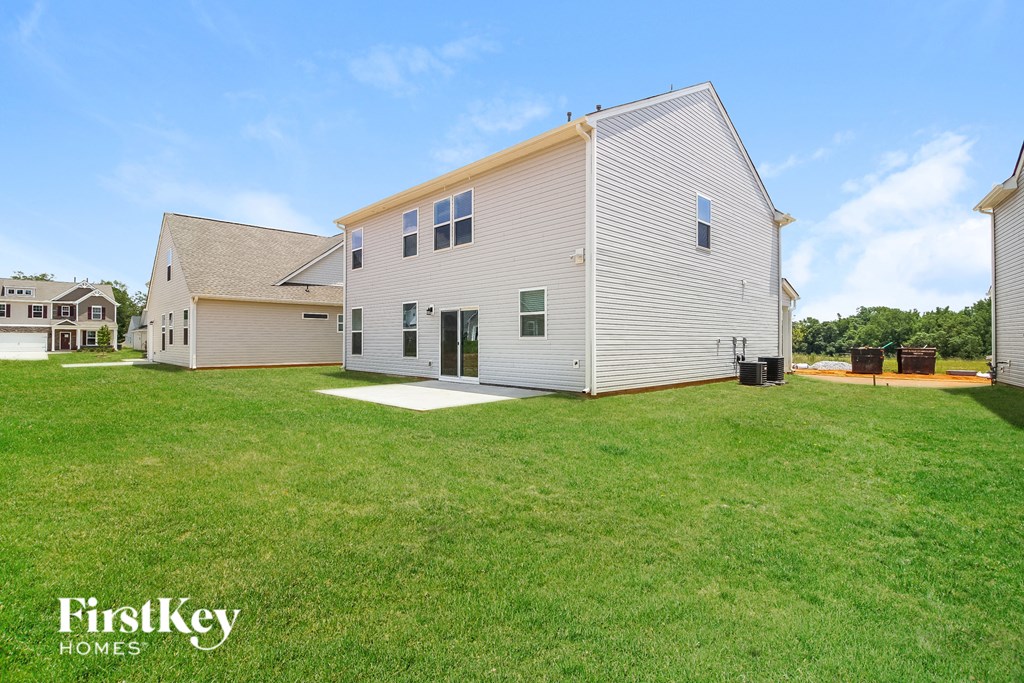 A white house with a green lawn in front of it.