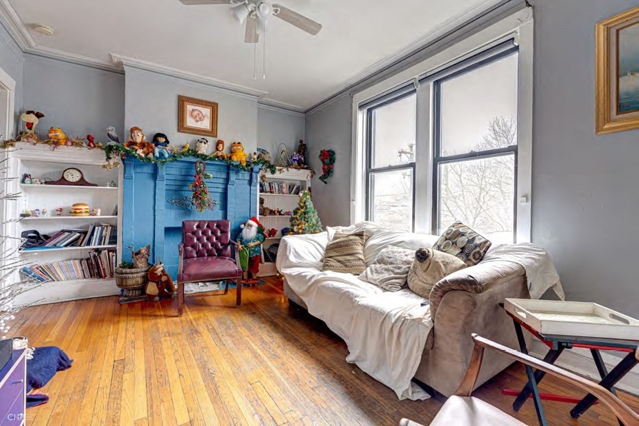 A room with a bed, a chair, a table, and a window.