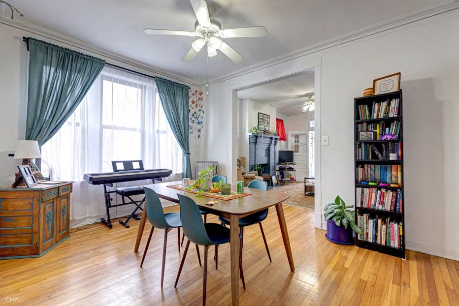 A room with a table, chairs, and a bookshelf.