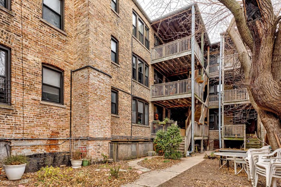 A courtyard with a tree and chairs.