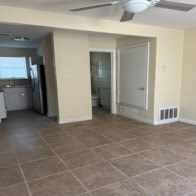 A kitchen with tile flooring and a ceiling fan.