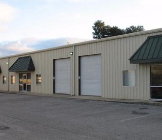 a large industrial building with two garage doors