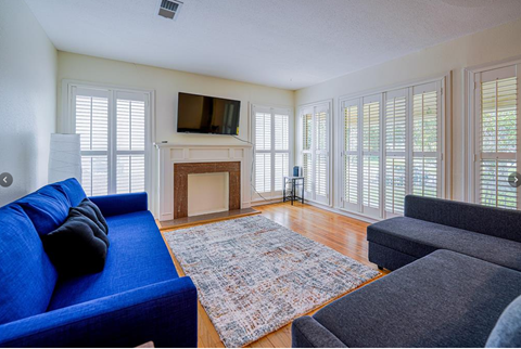 a living room with a blue couch and a fireplace