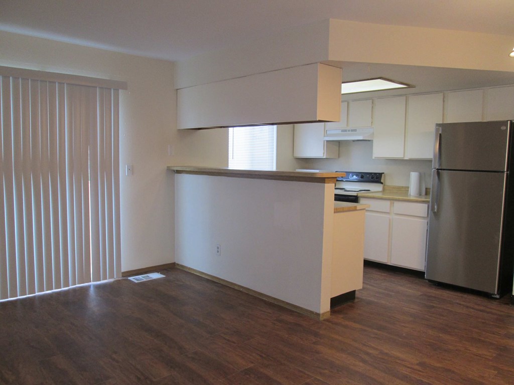 A kitchen with white cabinets and a stainless steel refrigerator.