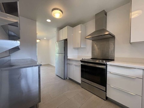 A modern kitchen with stainless steel appliances and white cabinets.