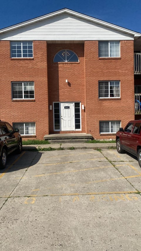 A red brick building with a white door and windows.