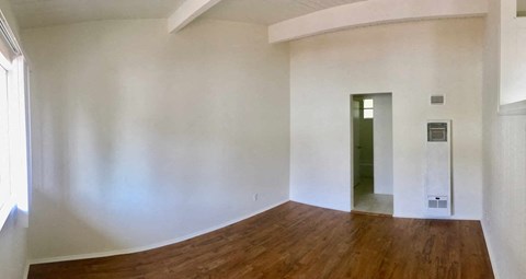 a living room with white walls and a wooden floor