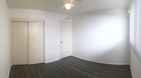 A room with two doors and a ceiling fan.