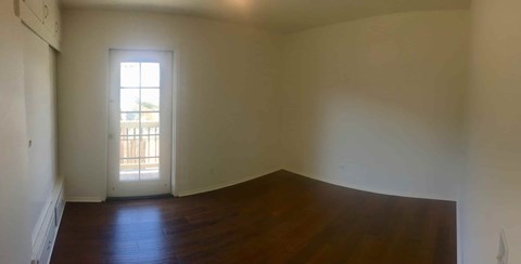 A room with a window and wooden floors.