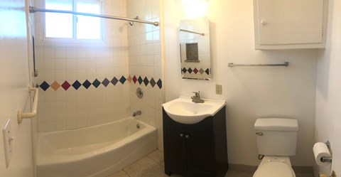 A bathroom with a white toilet, a white sink, and a white bathtub.