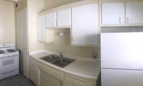 A kitchen with white cabinets and appliances.