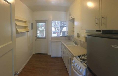 A kitchen with white cabinets and a stainless steel stove.