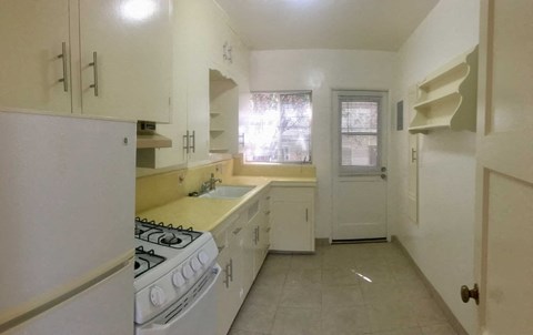 a kitchen with a stove and a sink and a refrigerator