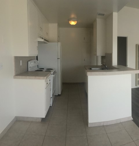 A kitchen with white appliances and cabinets.