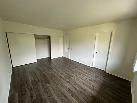 A room with wooden flooring and white walls.
