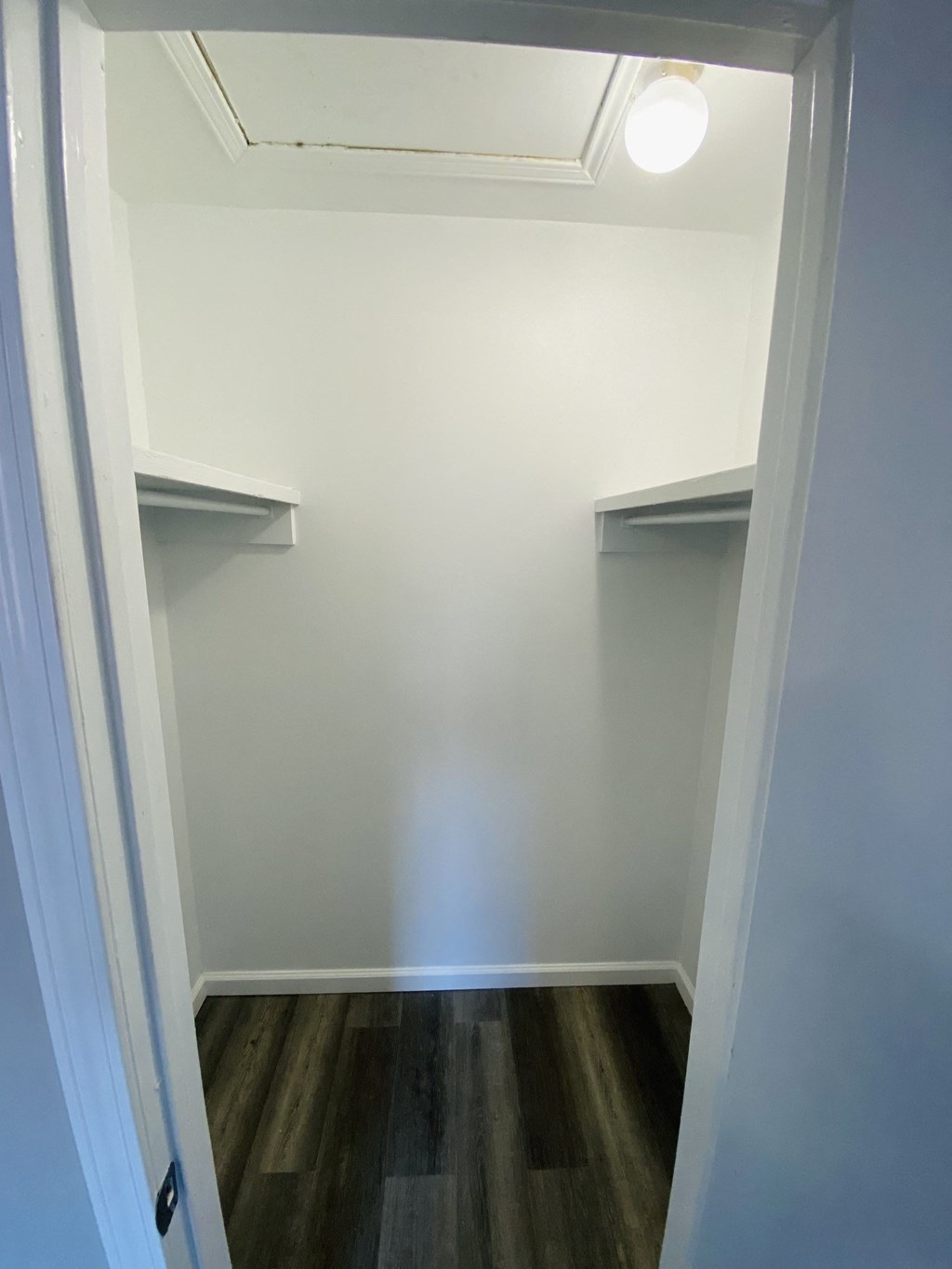 a room with two shelves on the wall and a wood floor