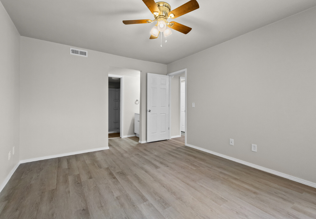 the living room of an empty house with a ceiling fan