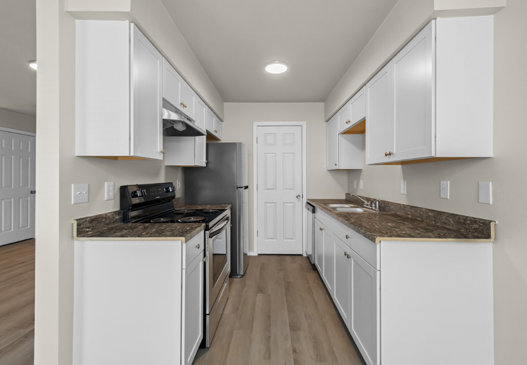a kitchen with white cabinets and a black stove and a refrigerator