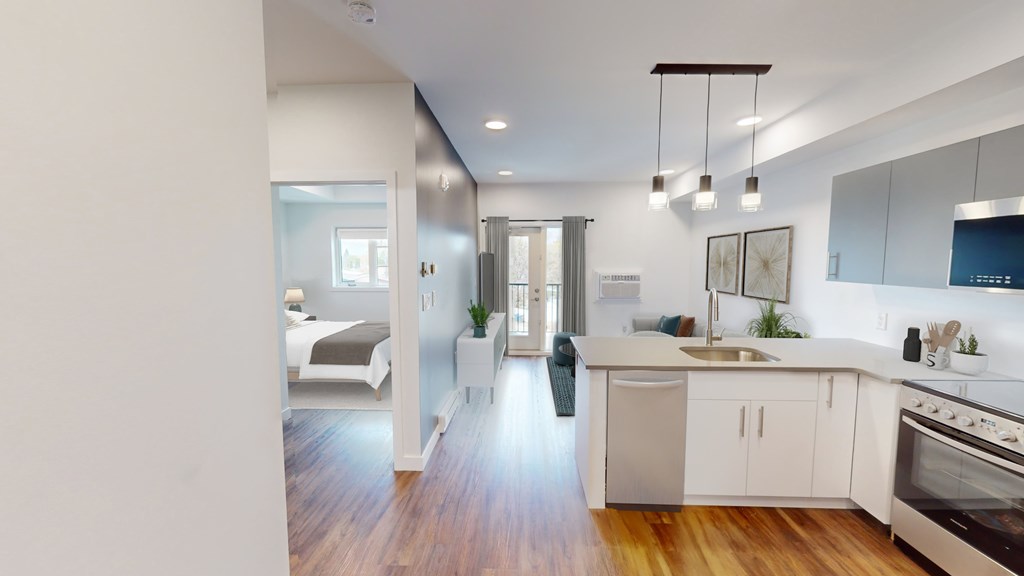 A modern kitchen with a stainless steel oven and white cabinets.