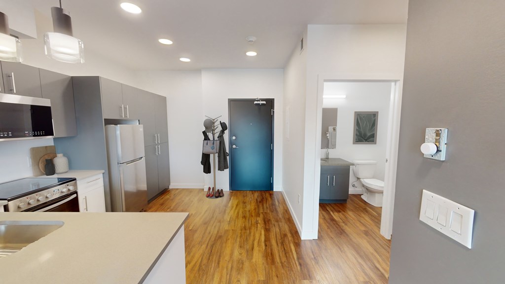 A kitchen with a refrigerator, oven, and sink.