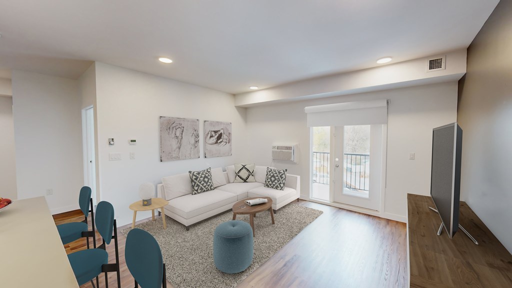 A living room with a white couch, a coffee table, and a television.