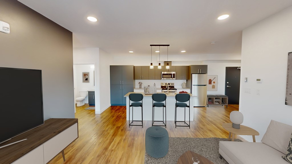 A modern living room with a bar area and a kitchen in the background.