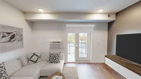 a living room with a couch and a tv and a door to a balcony