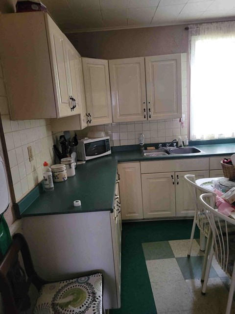 a kitchen with white cabinets and a green counter top