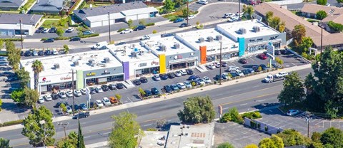 an aerial view of a shopping center with cars parked in a parking lot