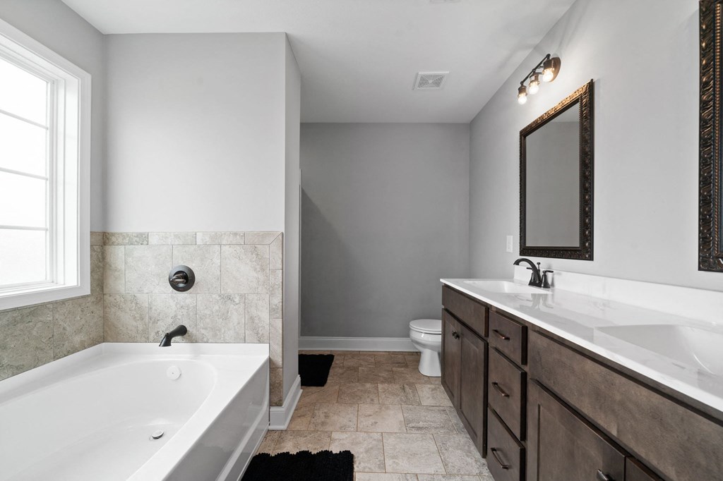 a bathroom with a tub and a sink and a toilet