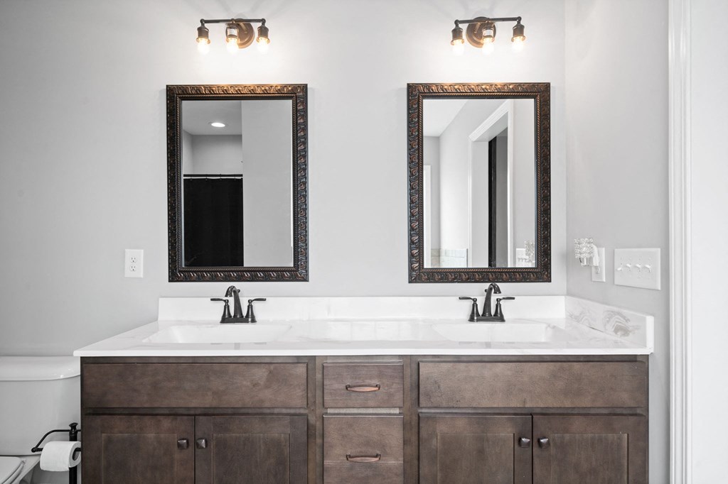a white bathroom with two mirrors and two sinks