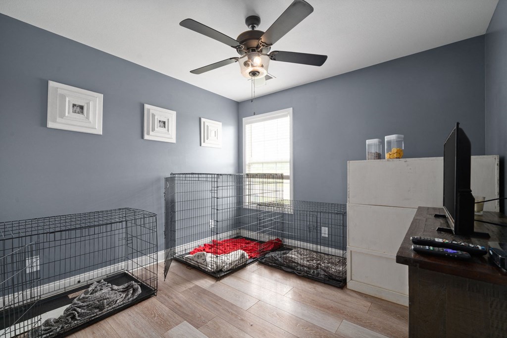 a room with two cages on the floor and a ceiling fan