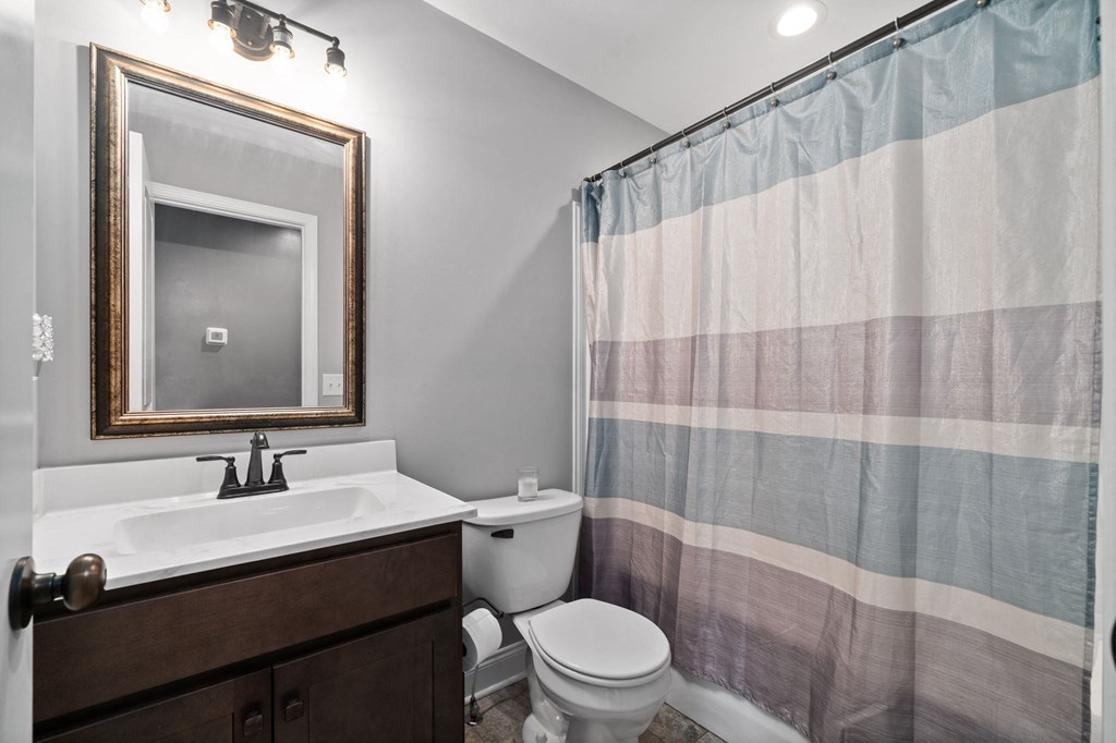 a bathroom with a shower curtain and a sink