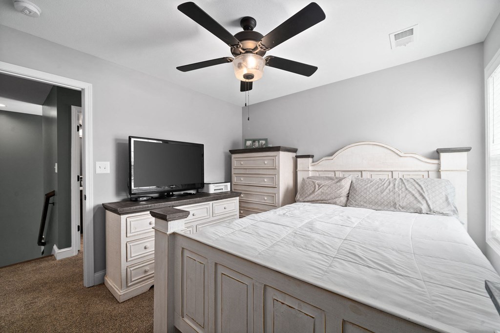a bedroom with a bed and a ceiling fan