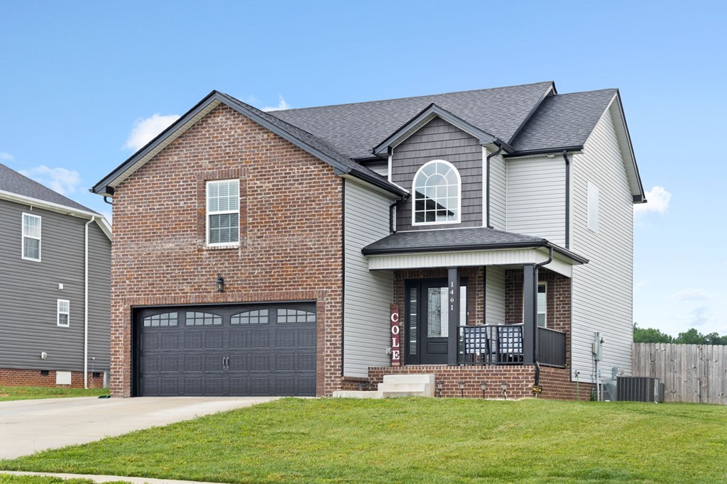 a house with a garage door and a lawn