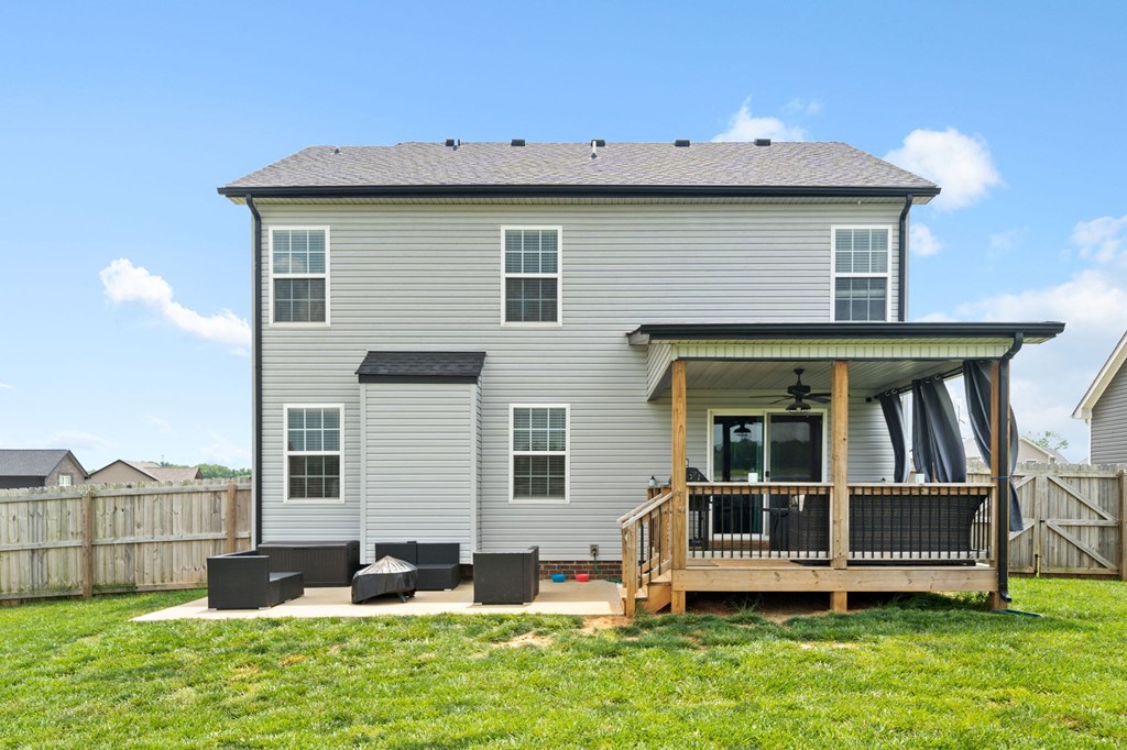the back of a house with a deck and a yard