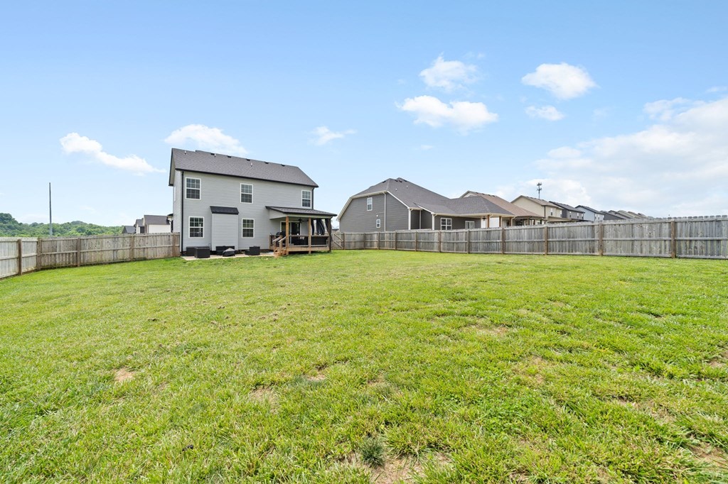 the backyard of a house with a large yard and a fence