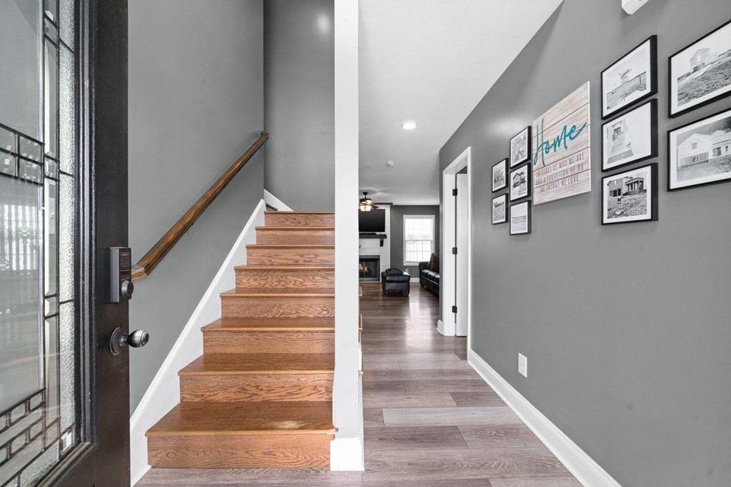 a staircase in a house with wood floors and grey walls