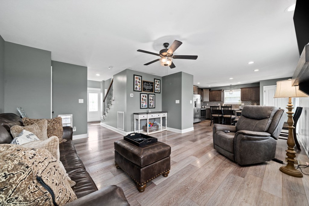 a living room with furniture and a ceiling fan