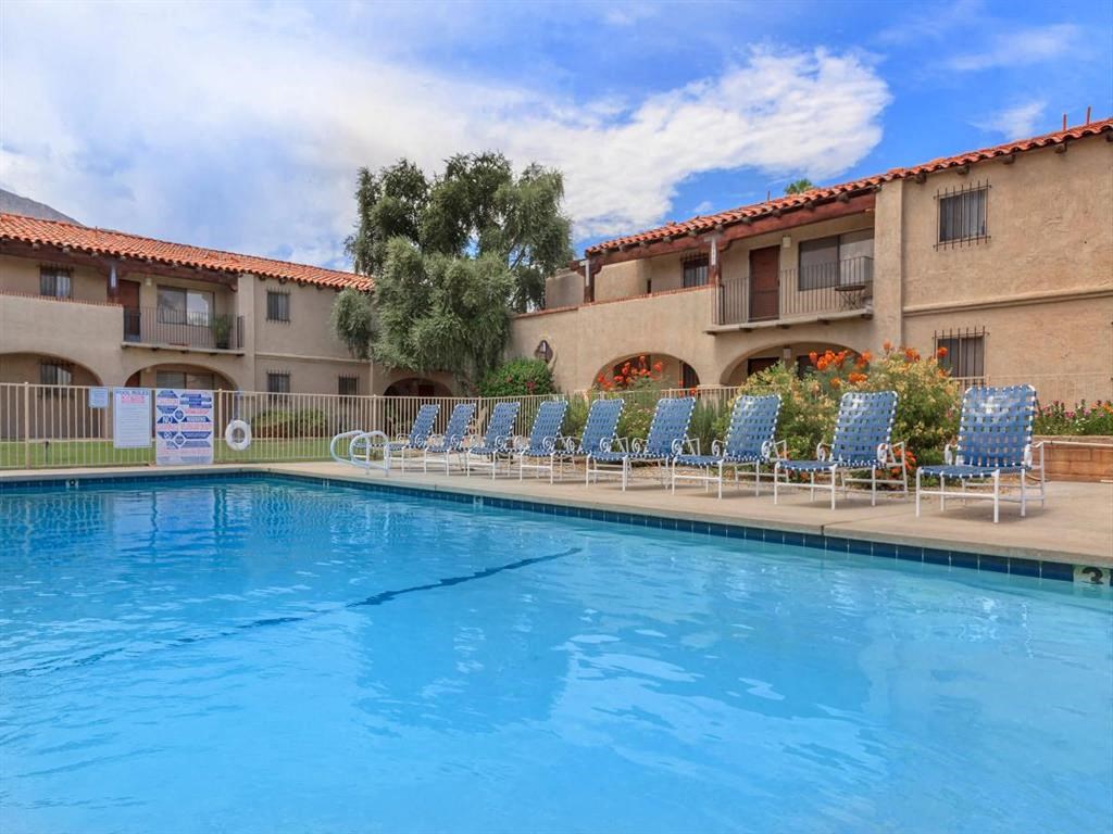 a large swimming pool in front of a hotel