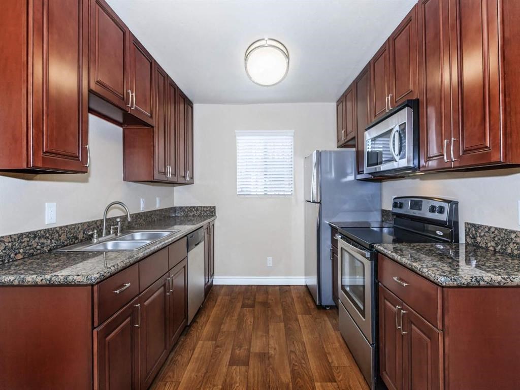 a kitchen with wooden cabinets and stainless steel appliances
