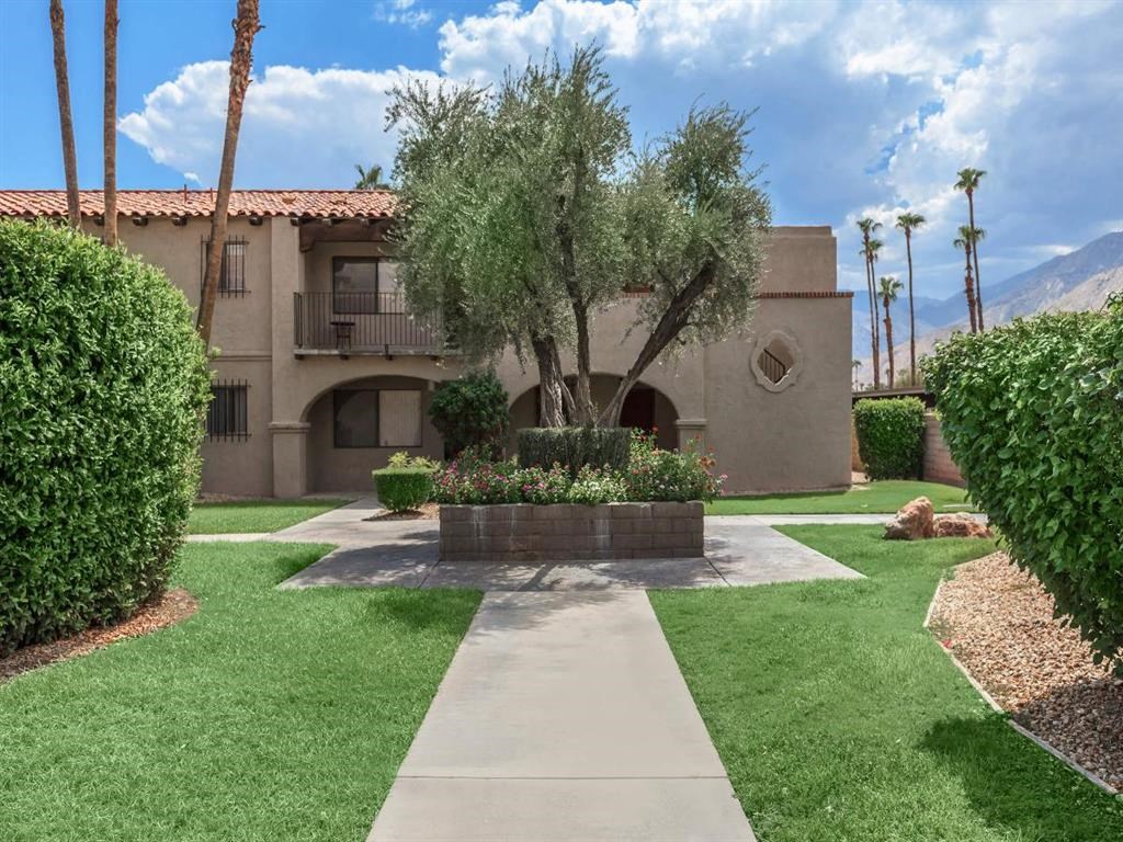 a yard with a house and a tree in the middle