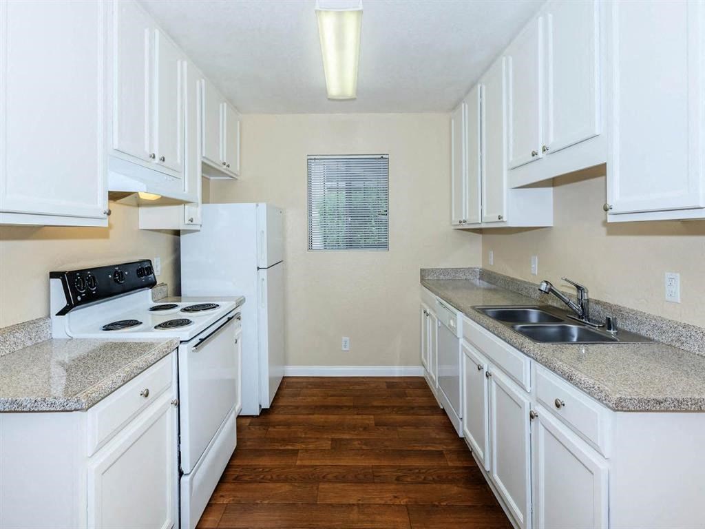 a kitchen with white cabinets and a stove and a sink