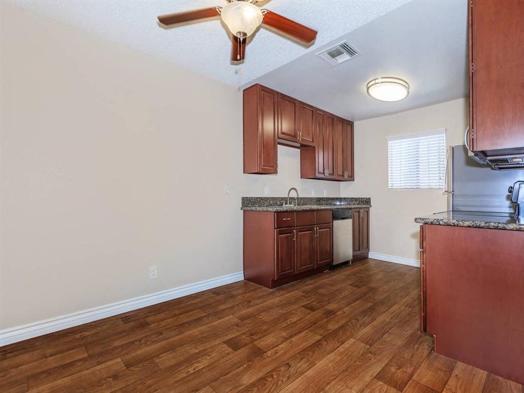 an empty kitchen with wood flooring and wooden cabinets