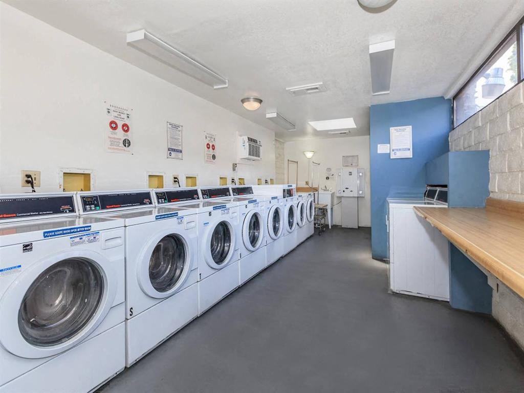 a laundry room with a row of washing machines