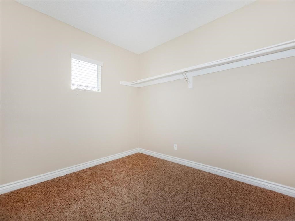 a bedroom with a carpeted floor and a white closet