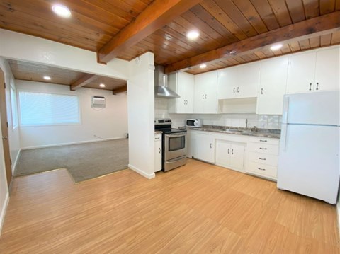 A kitchen with white cabinets and a white refrigerator.