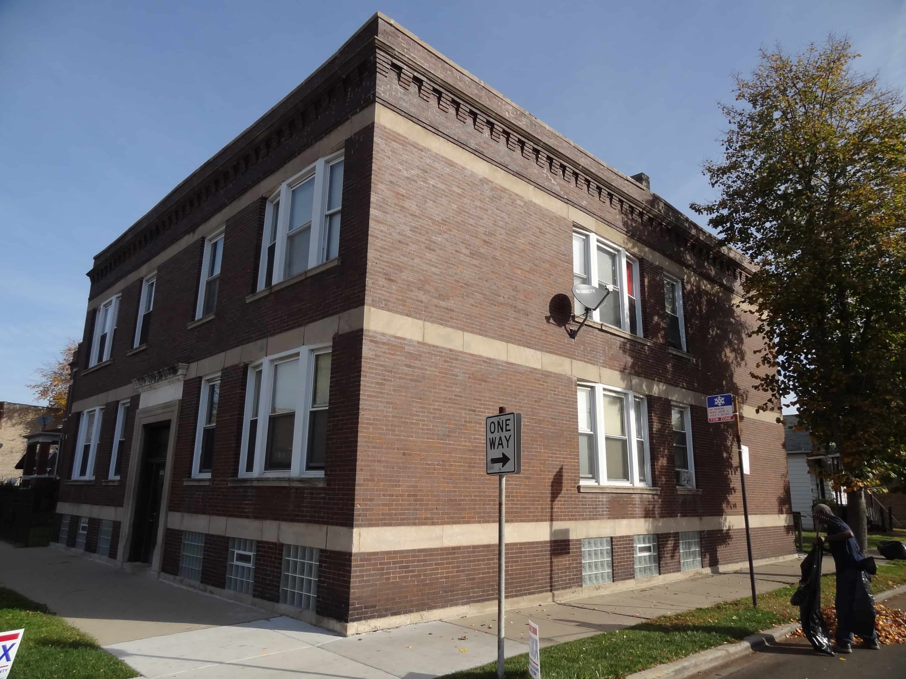 a brick building with a street sign in front of it