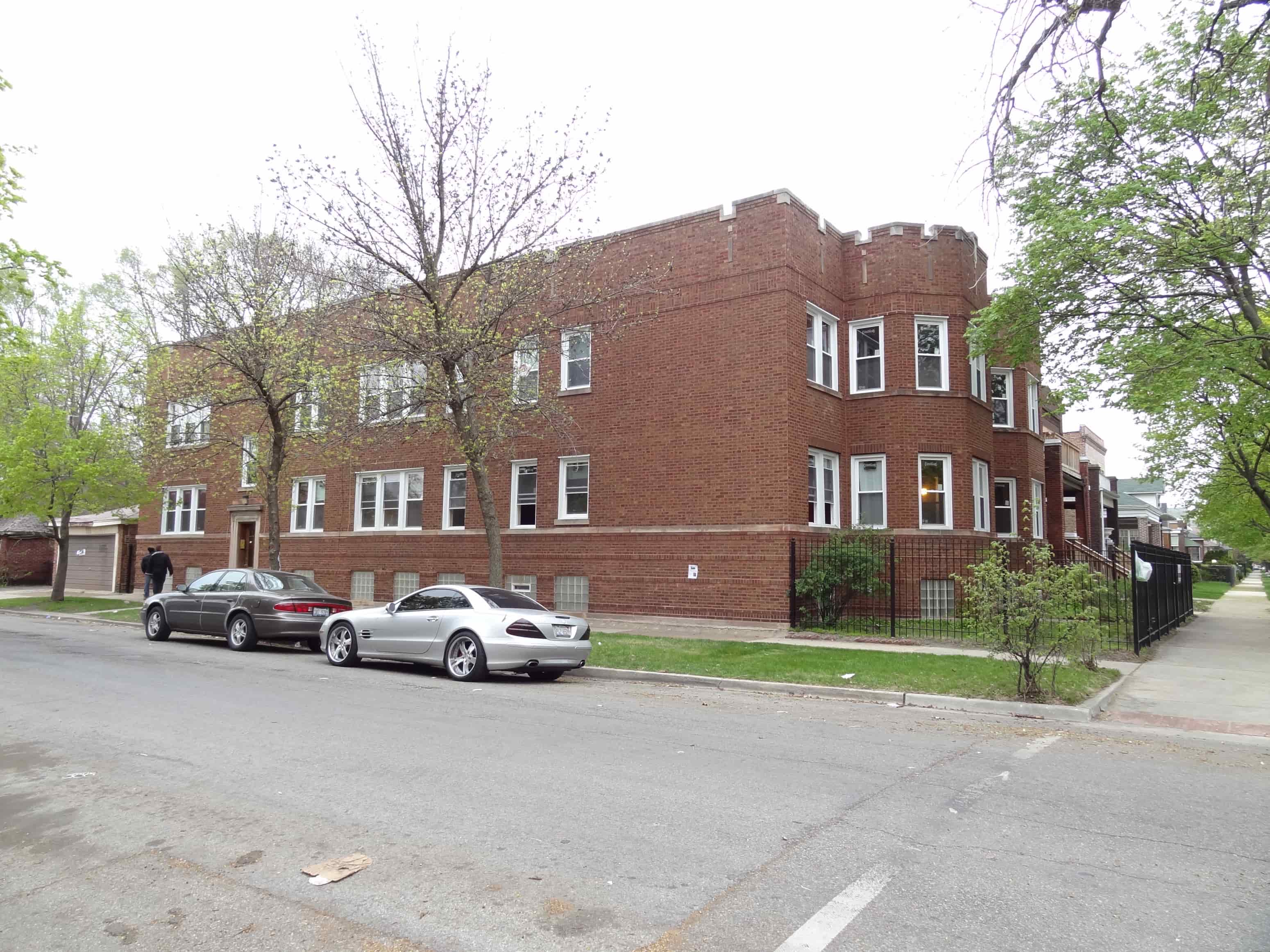 a large brick building with cars parked in front of it